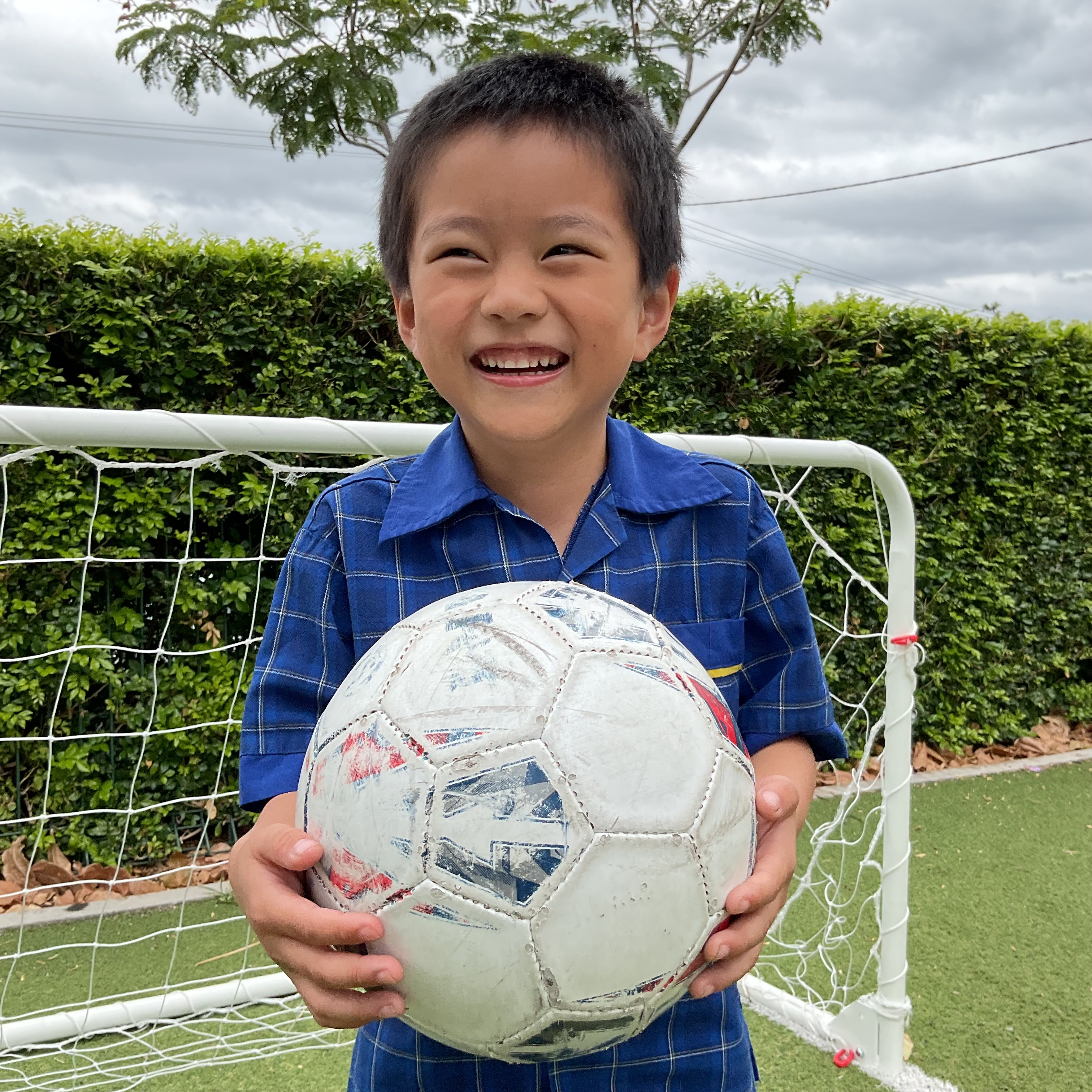 Student holding a soccer ball in front of a goal, highlighting participation in sport, confidence and active play at Holy Spirit School